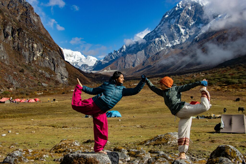 Two women practicing yoga in the scenic Himalayas, Thangsing, Sikkim.