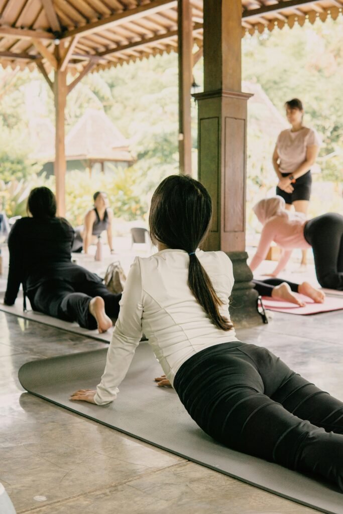 pexels-photo-35978212-35978212 Outdoor yoga session in Jawa Barat, Indonesia featuring diverse participants practicing in tranquility.
