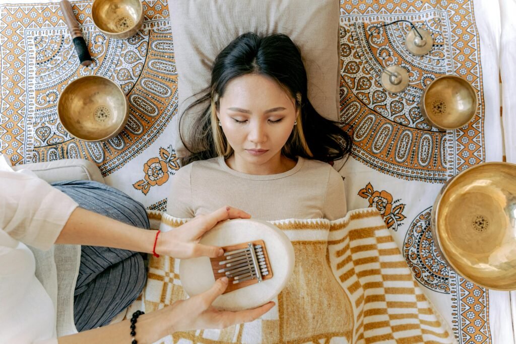 pexels-photo-6252169-6252169 A serene meditation scene featuring a woman with kalimba and singing bowls, promoting relaxation and well-being.